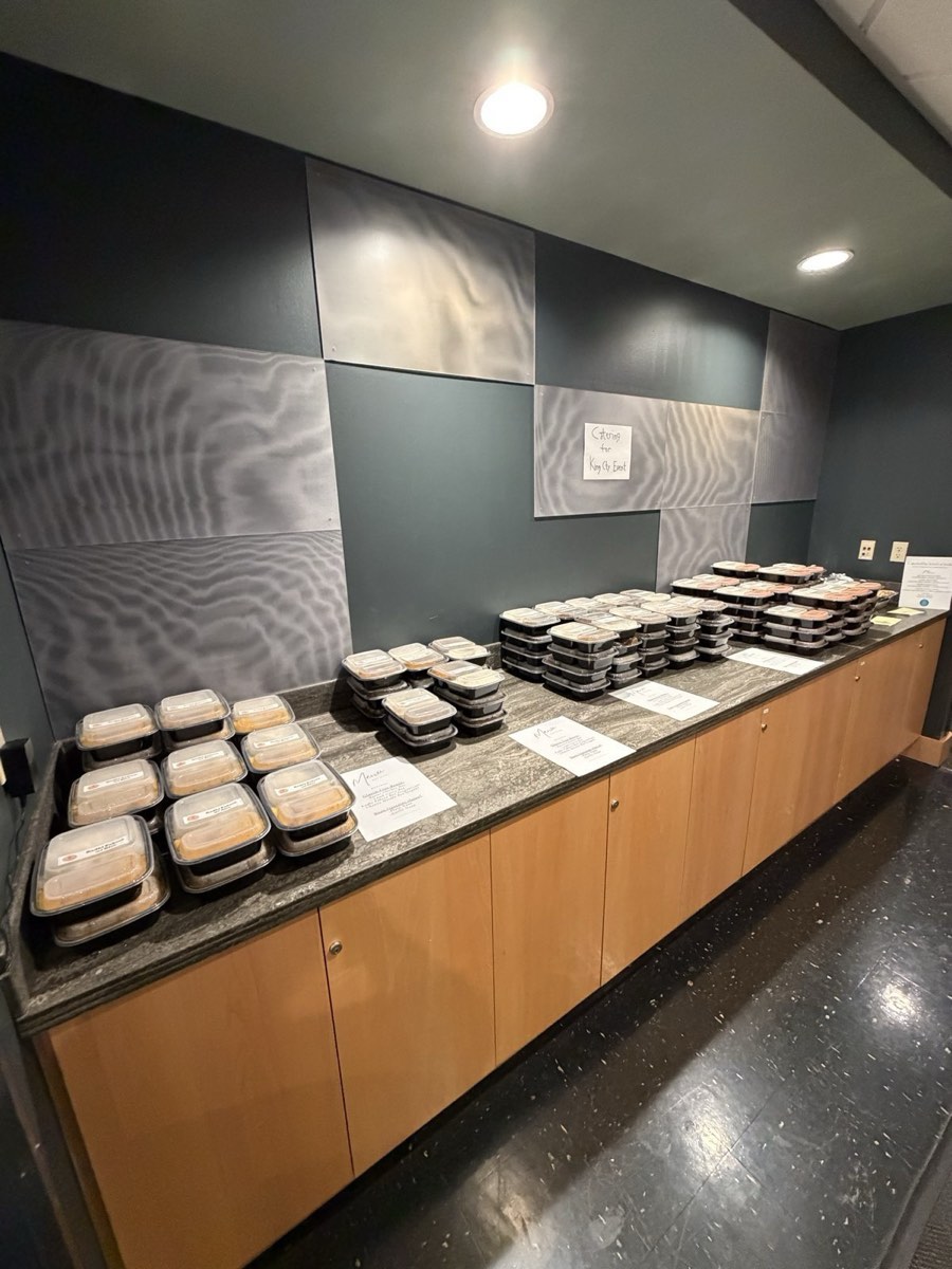 Individually boxed Indian meals laid out along a counter with menu cards for a Redmond corporate event